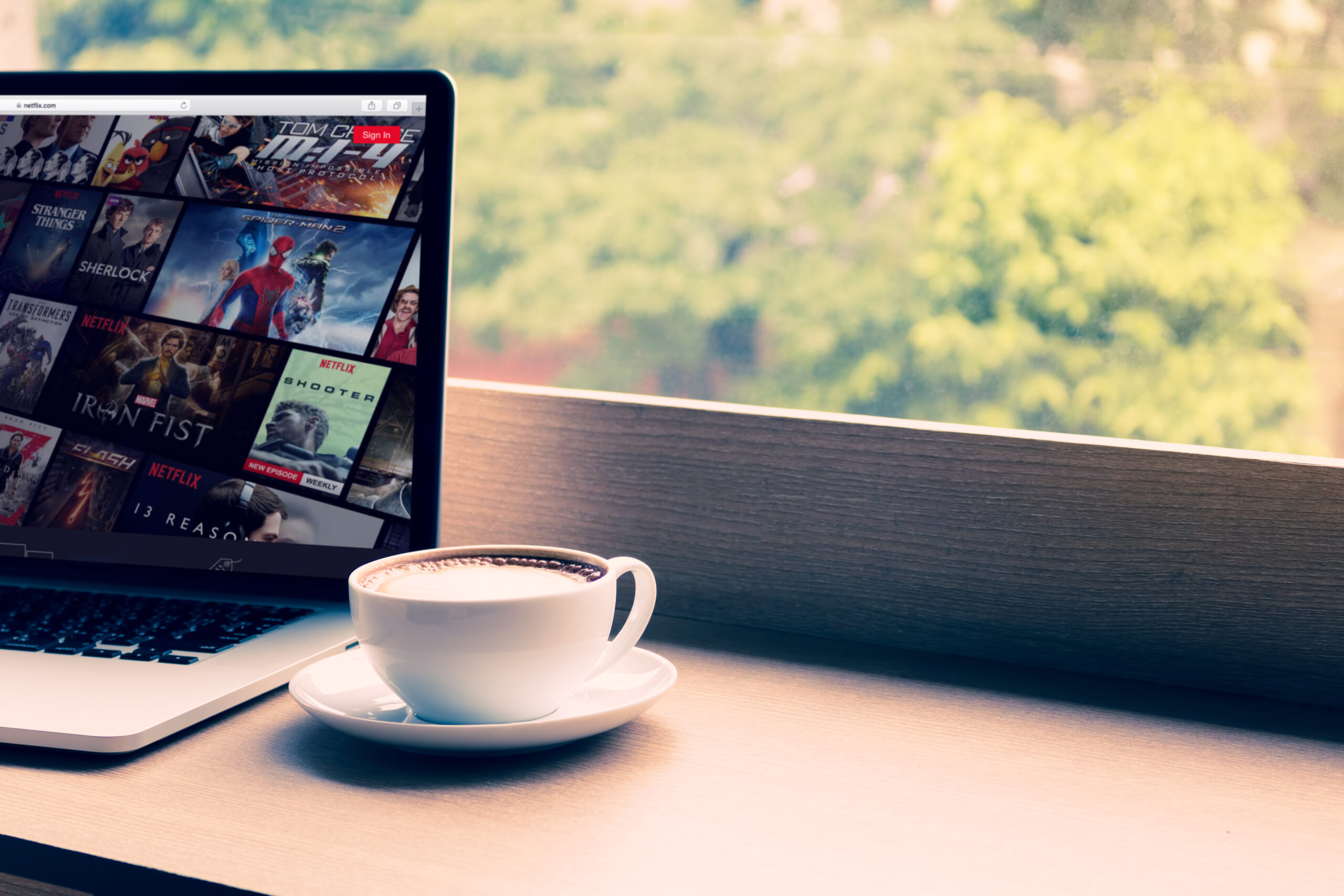 Chiang Mai: Netflix website showing on screen laptop with macbook pro at cafe. Netflix being popular internationally